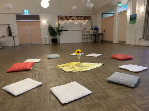 Zaal met kussens voor de deelronde en korte inleiding van de les.