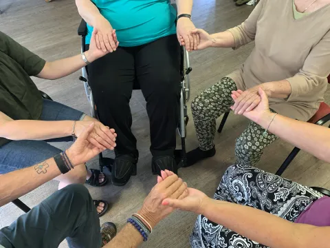 Klein groepje zittend met de handen vast